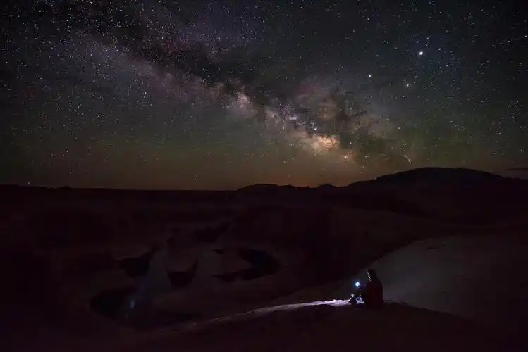 坐在山上流星星空夜晚看星星一个人黑色剪影