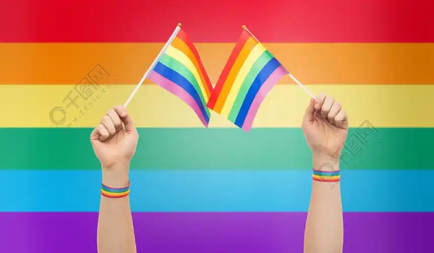 拿着彩虹旗子手与同性恋骄傲彩虹旗和腕带手与同性恋骄傲彩虹旗和腕带