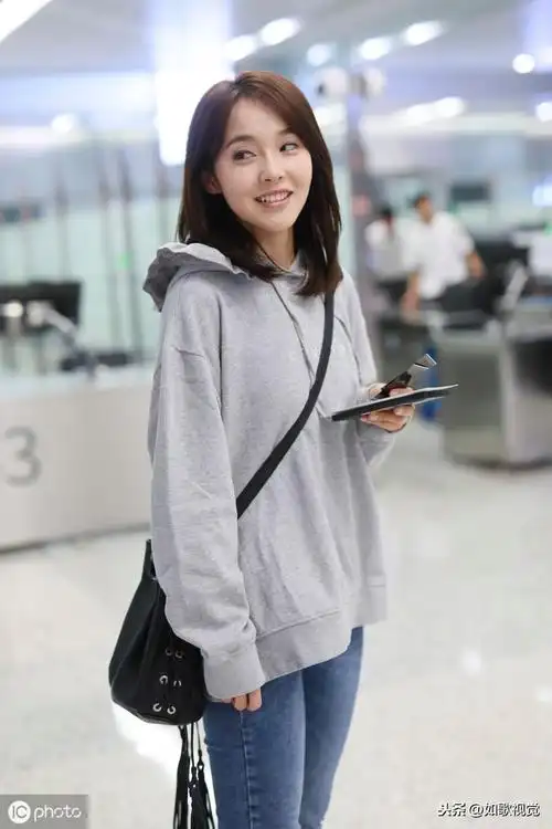 张佳宁现身机场身穿灰色卫衣配紧身牛仔裤举止婀娜呆萌可爱