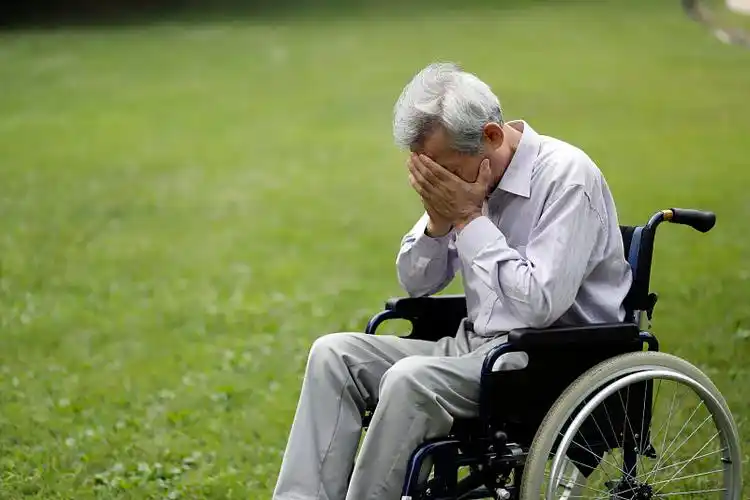 一个坐在轮椅上的老人饱受头痛之苦图片下载