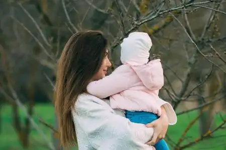 带着两个女儿坐在公园里母亲带着女儿做面包肖像快乐的小孩子抱着枕