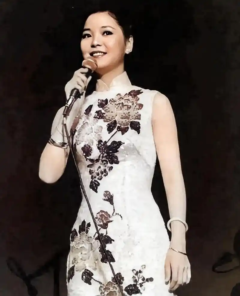 这张照片是身穿绣花旗袍在舞台表演的邓丽君.
