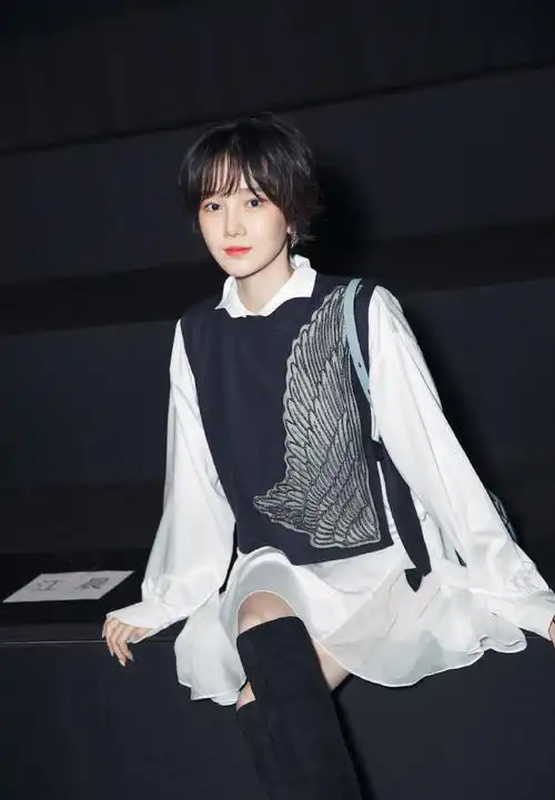 脚踩一双黑色高筒靴,直接玩下衣失踪,露出一截美腿,可以说相当高调.