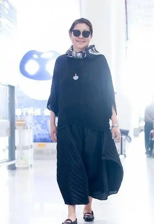 倪萍的其他造型分析:倪萍在脚上搭配了一双黑色的运动鞋,经典的色彩