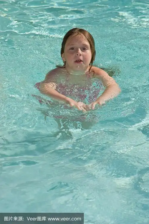 小女孩在游泳池里游泳