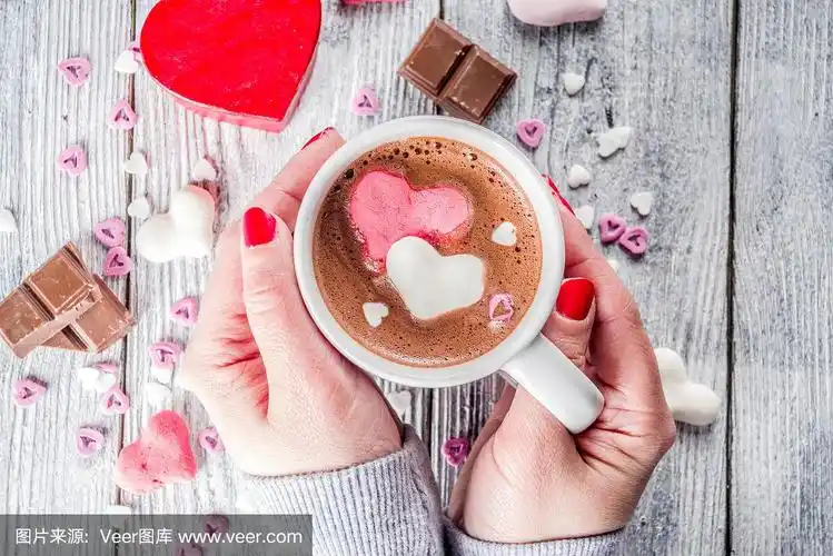 女孩的手握热巧克力与棉花糖心