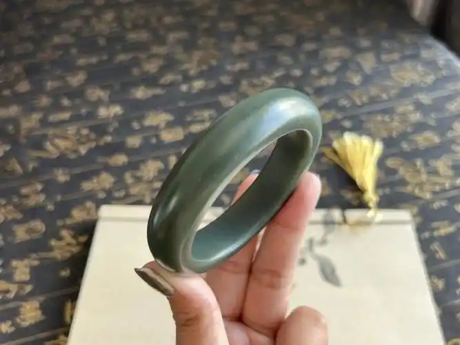 沙枣青籽料手镯,质地非常干净且油润,沙枣青质地很像是绸缎,完美有