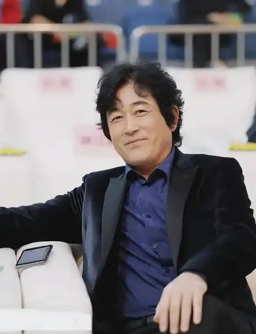 照片中,王志飞身穿海军蓝色西装,内搭蓝色衬衫.