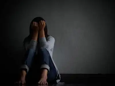 悲伤的女人抱着她的膝盖和哭泣.悲伤的女人独自坐在空荡荡的房间照片