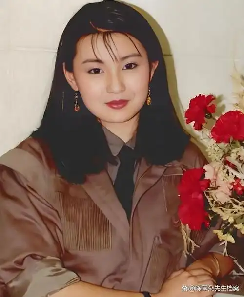 张曼玉棕色制服,黑色领带,外貌端庄秀丽,气质迷人优雅