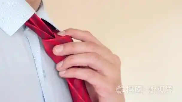 一名商人脱下他的红色领带,解开他的衬衫上的扣子最上端的按钮.