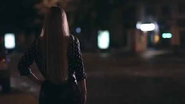 晚上在城市的街道上搭便车的迷人 i> i>女 /i> /i> i> i>孩 /i> /i>的