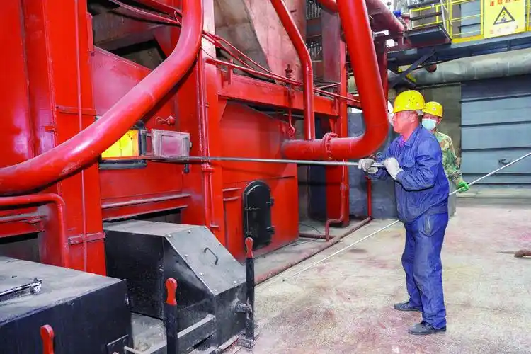 在长热集团新诚供热公司锅炉房,工人师傅正通过手动调节煤层,让煤得到