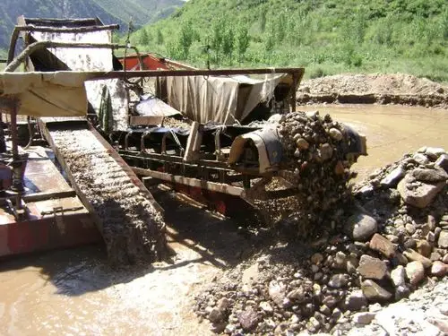 出来,留下的沙子经过皮带输送机,输送到鼓动溜槽进行第一次砂金矿初选