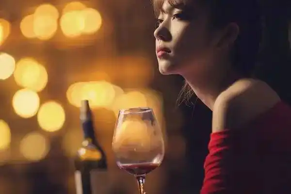 爱喝葡萄酒的女人优雅庄重纤手执杯,轻轻晃动,慢斟酌饮.