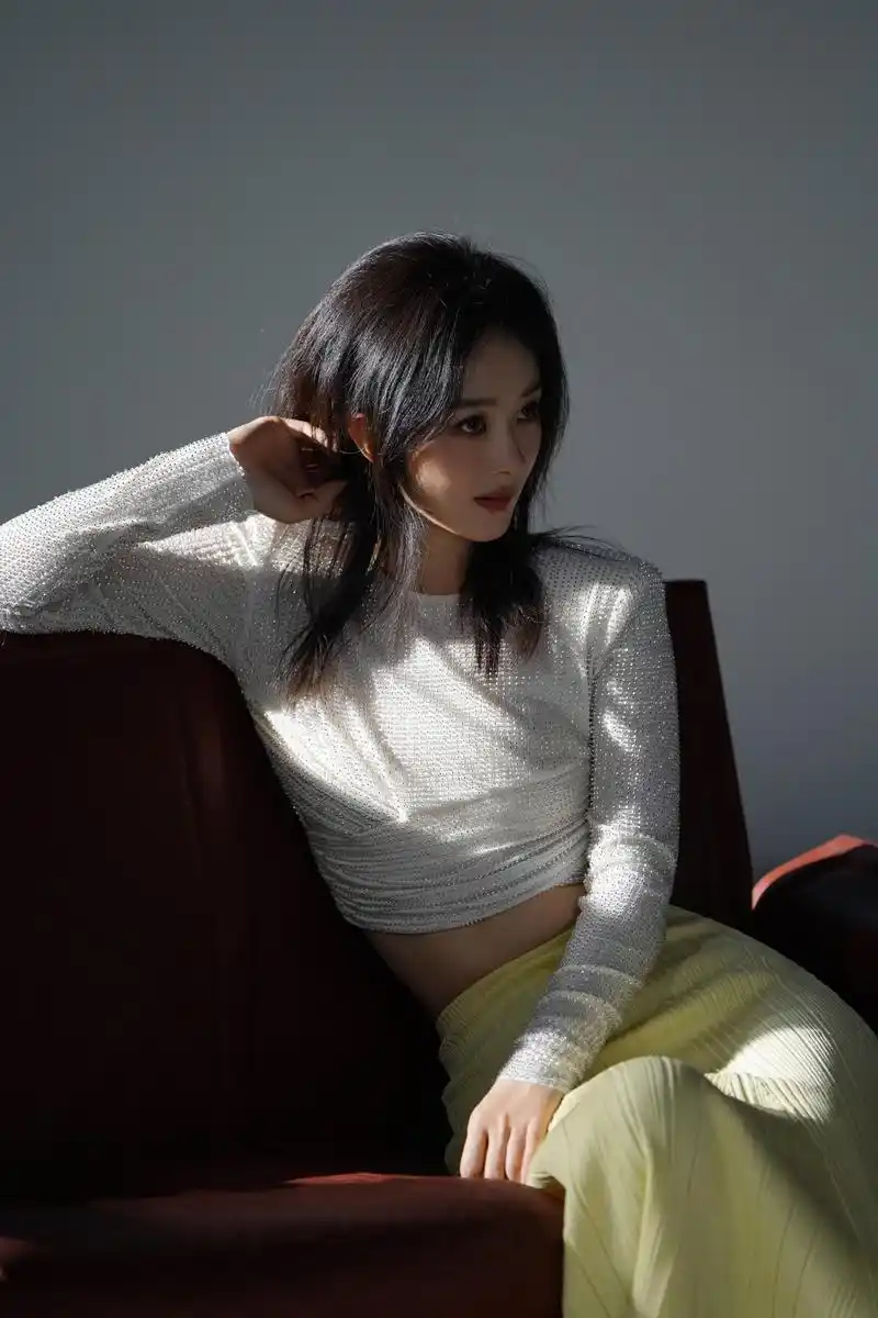 赵丽颖白色烫钻扭结上衣 赵丽颖身着白色烫钻扭结上衣,搭配黄色针织