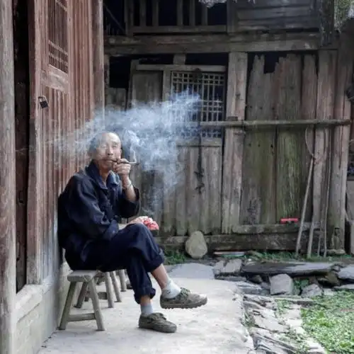 等老人休闲的时候总会拿张小凳子坐在门口抽上点烟