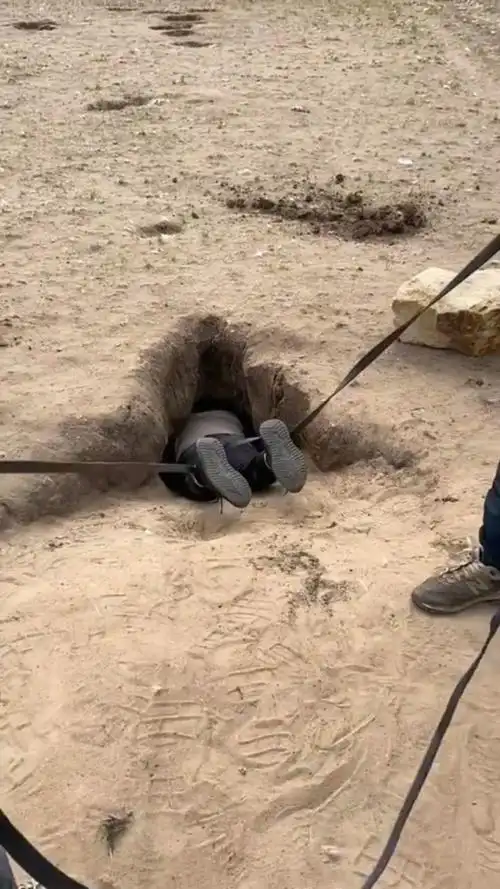 小伙子自告奋勇钻进洞里把狗崽救了出来,真是好人