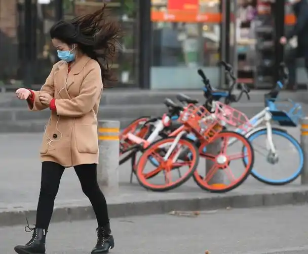 行人被大风吹得头发凌乱.新京报记者 王颖 摄