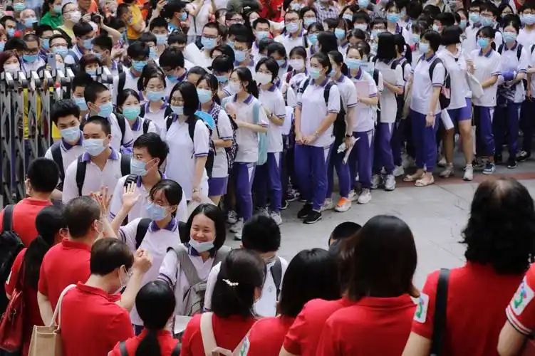 7月-7月8日,广州市第十六中学,高考生排队与老师击掌进考场.