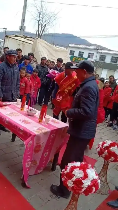 农村新人在户外拜天地,村里人都来围观