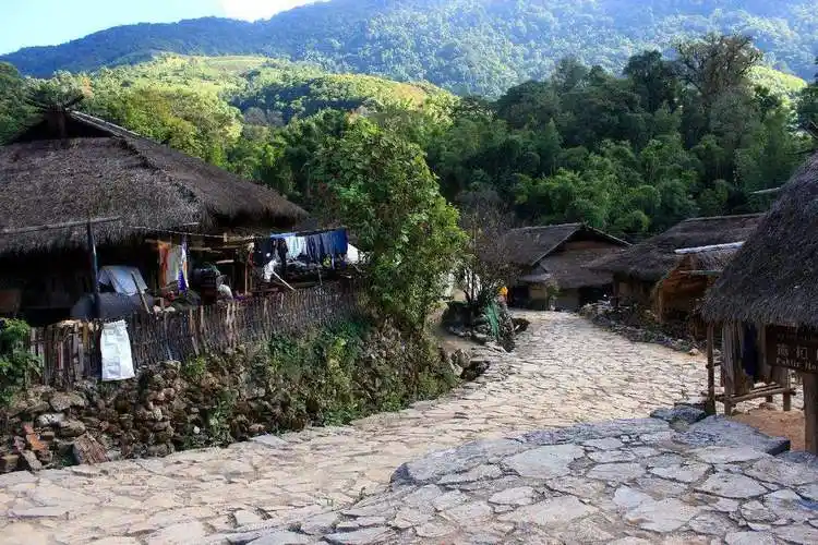 翁丁佤寨依山而居,几十间茅草屋错落紧挨,远远望去就像一朵朵的蘑菇.