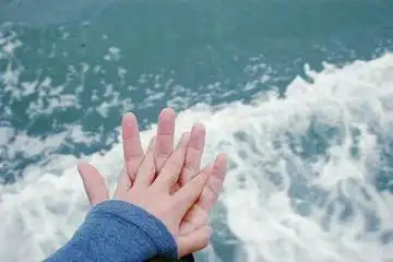 双手戒指图片唯美.你们相对而立,纵身一跃,情侣双手紧握.