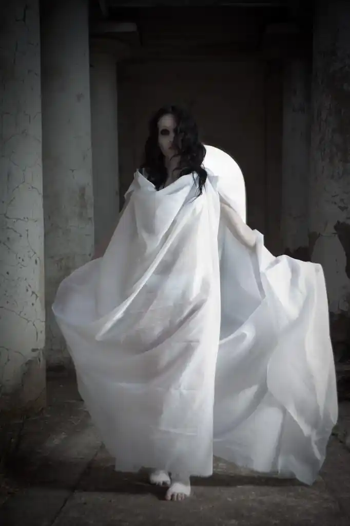 孤独的鬼魂,行走在古老的墓地,穿白衣服的漂亮女孩