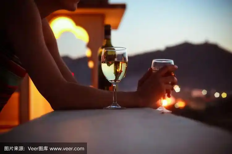 一个在印度度假的女人在夕阳下喝酒