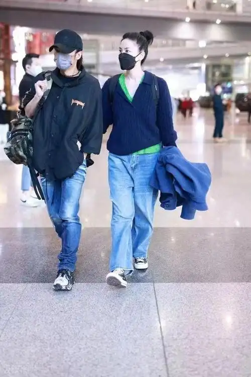 王菲牵谢霆锋走机场扎马尾像高中生小男友单手插兜扮酷