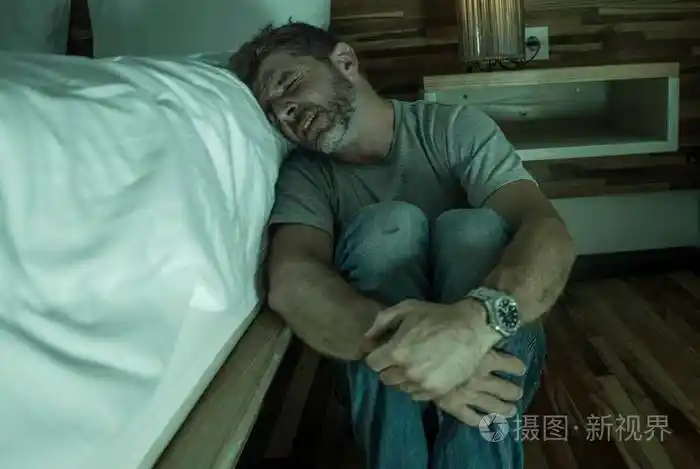 抑郁孤独的男子坐在卧室地板上哭生病遭受焦虑危机和抑郁问题感到无助