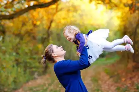 妇女与美丽的女婴在自然和森林.妈妈带着小孩子在户外, 拥抱.
