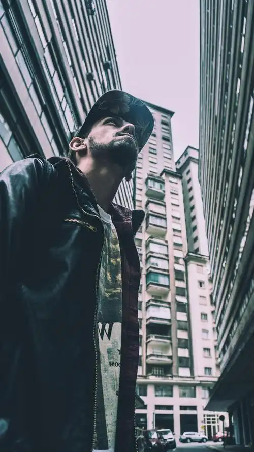 黑暗背景前穿粉色衣服的男人