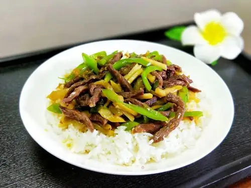 将榨菜牛肉青椒丝铲入米饭表面,盖浇饭完成.