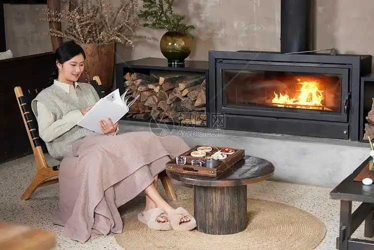 在火炉边取暖看书的女性
