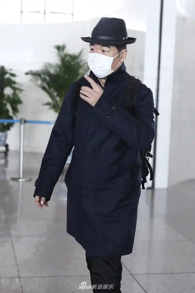 组图:张国立黑色look现身机场 背双肩包大步流星精气神足