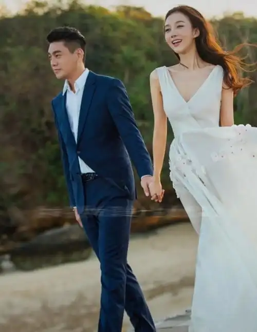 韩雯雯被朱孝天牵着走过海边,穿着婚纱和西装,笑起来十分甜美.