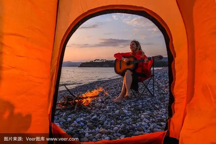 在海滩上弹吉他的女人.