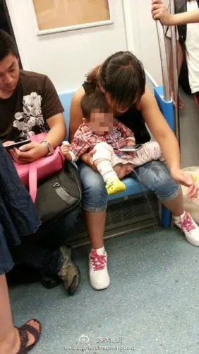 地铁一妇女抱孩子当众撒尿图