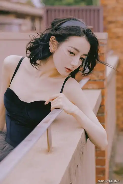 热巴靠在阳台的栏杆上,黑色吊带大秀香肩,锁骨十分抢镜,这张照片的