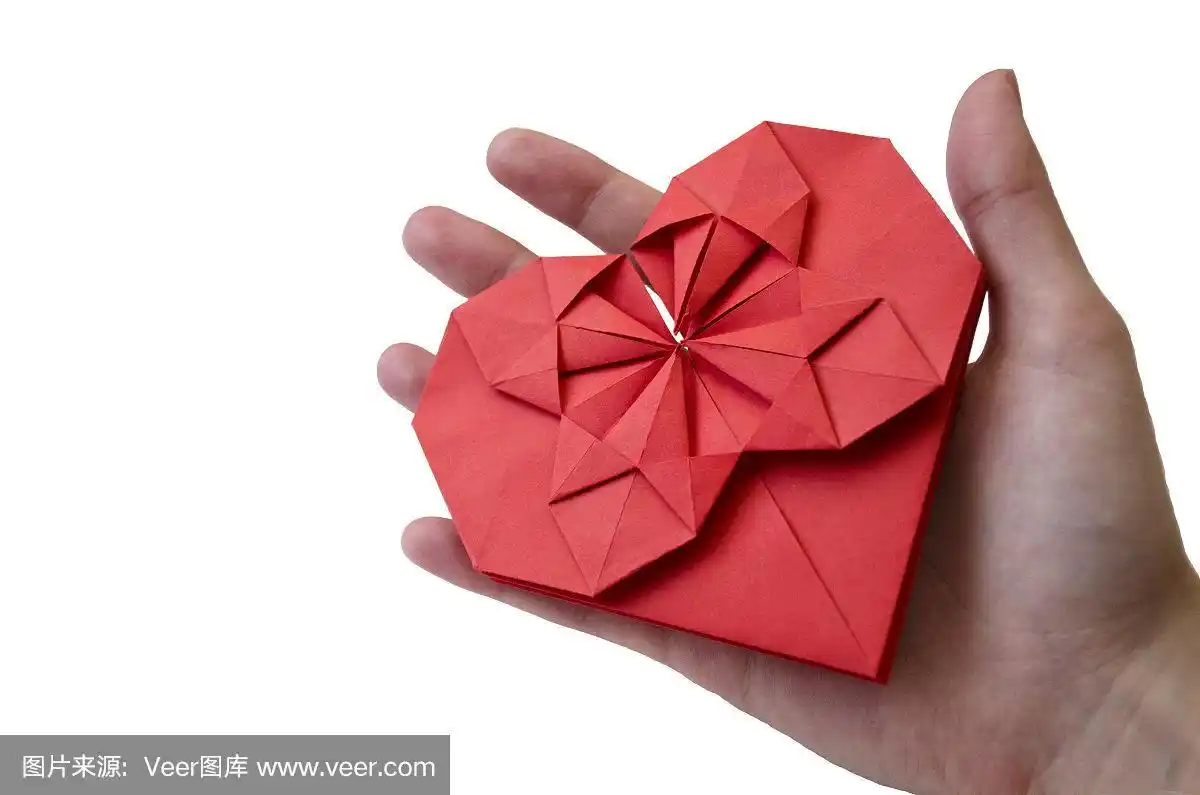 孤立的红纸心折纸技术在女性的手在白色的背景.