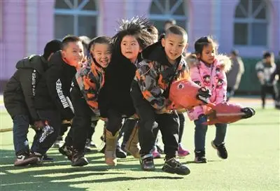 12月14日,河北省乐亭县第三幼儿园的孩子们在玩骑竹马游戏.