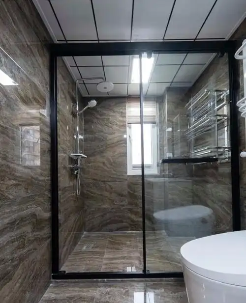 卫生间墙地砖一体,通铺深色系全抛釉瓷砖,搭配白色浴室镜和洗手台浴室