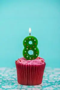 蓝色背景上的数字 8 蜡烛生日杯蛋糕照片