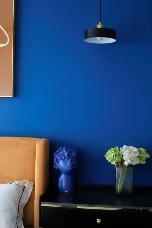 摩登时尚的橙色挂画,和床背,窗帘等橙色元素一起和蓝色背景墙形成强烈