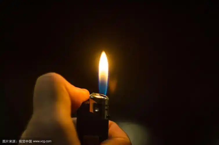 手点燃打火机孤立在黑色背景