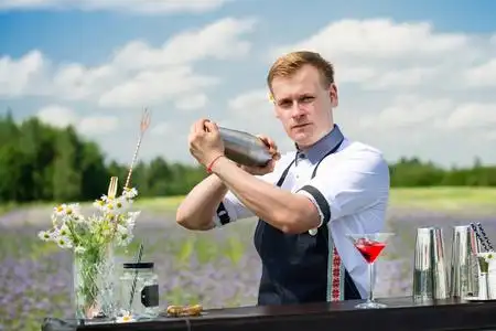 帅气的调酒师在酒吧柜台附近准备鸡尾酒,户外照片