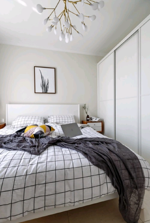 简单而温馨的卧室,浅米色的墙面与纯白色的床品营造出安静的氛围.