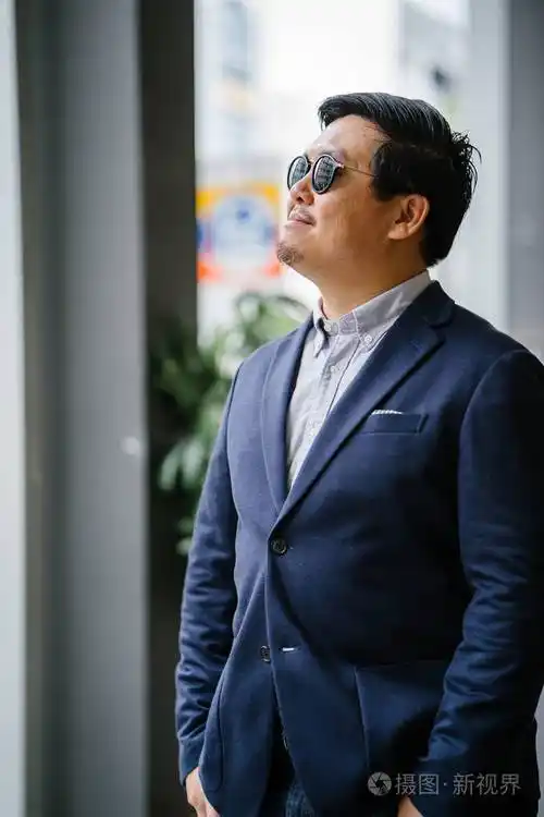 一位中年中国亚裔男子(新加坡人)的肖像,穿着智能休闲,站在城市里.