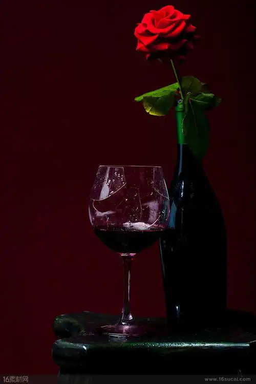 在红色玫瑰花旁边的红酒杯高清摄影图片